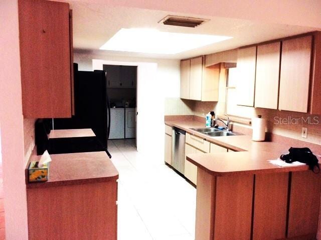 23220 Rountree Ave, Port Charlotte, FL 33980 - kitchen featuring washer and dryer, a peninsula, light countertops, dishwasher, and refrigerator