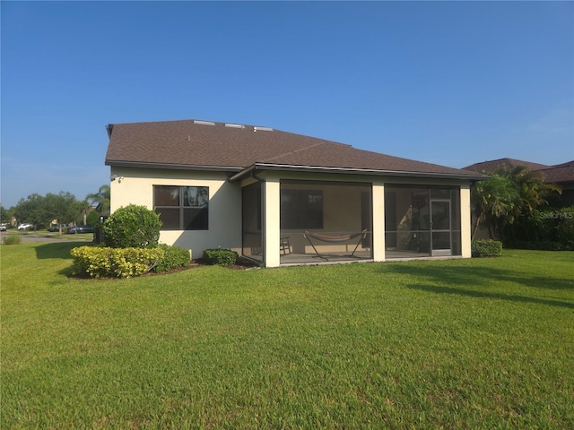 2739 Sherman Oak Dr, North Port, FL 34289 - back of property with a lawn, a sunroom, roof with shingles, and stucco siding
