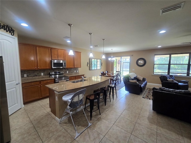 2739 Sherman Oak Dr, North Port, FL 34289 - kitchen with stainless steel appliances, a sink, recessed lighting, light tile patterned flooring, and open floor plan