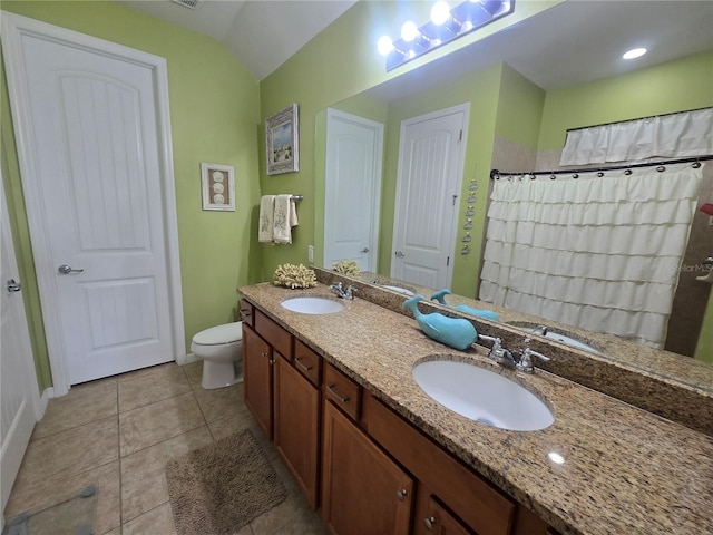 2739 Sherman Oak Dr, North Port, FL 34289 - bathroom with double vanity, toilet, baseboards, tile patterned flooring, and vaulted ceiling