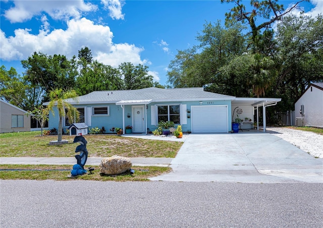 7231 Elyton Dr, North Port, FL 34287 - ranch-style house with concrete driveway, a front yard, an attached garage, a carport, and central AC unit