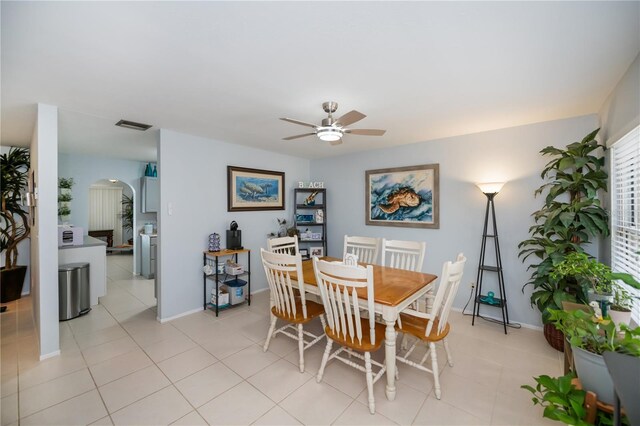 7231 Elyton Dr, North Port, FL 34287 - dining room with a ceiling fan, arched walkways, baseboards, and light tile patterned floors