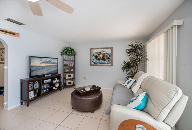 7231 Elyton Dr, North Port, FL 34287 - living area with arched walkways, light tile patterned floors, a ceiling fan, and baseboards