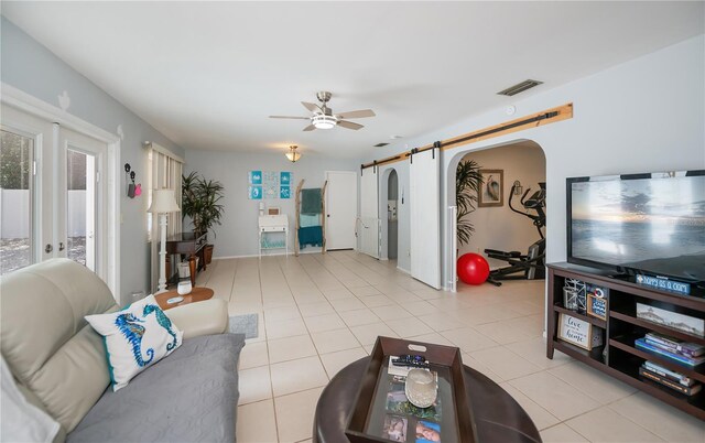 7231 Elyton Dr, North Port, FL 34287 - living area featuring a ceiling fan, a barn door, arched walkways, and light tile patterned flooring