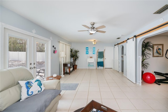 7231 Elyton Dr, North Port, FL 34287 - living area featuring ceiling fan, french doors, a barn door, baseboards, and arched walkways
