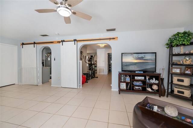 7231 Elyton Dr, North Port, FL 34287 - living room featuring arched walkways, ceiling fan, a barn door, and light tile patterned floors
