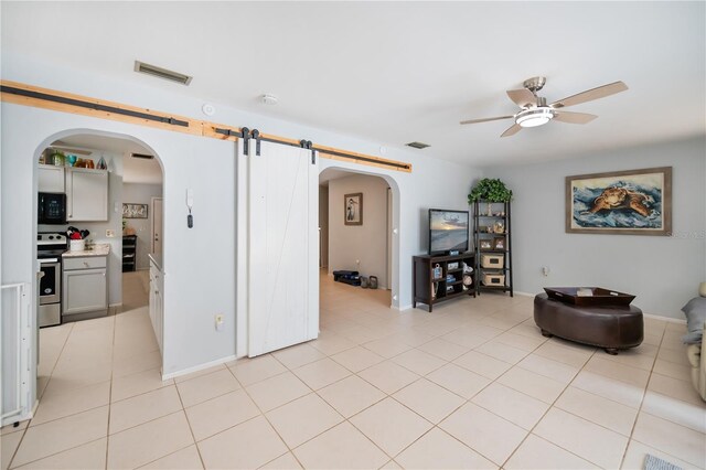 7231 Elyton Dr, North Port, FL 34287 - living room with arched walkways, a ceiling fan, light tile patterned floors, and baseboards