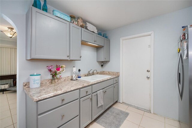 7231 Elyton Dr, North Port, FL 34287 - kitchen with a sink, gray cabinetry, freestanding refrigerator, and light tile patterned floors