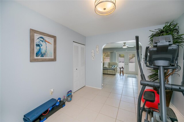 7231 Elyton Dr, North Port, FL 34287 - workout area featuring arched walkways, french doors, baseboards, ceiling fan, and light tile patterned flooring