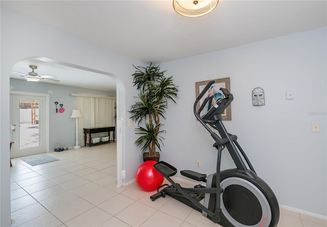 7231 Elyton Dr, North Port, FL 34287 - workout area featuring arched walkways, ceiling fan, light tile patterned floors, and baseboards