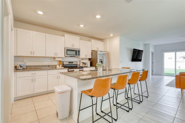 111 Rain Lily Ave, Spring Hill, FL 34609 - kitchen with stainless steel appliances, a center island with sink, white cabinets, and recessed lighting