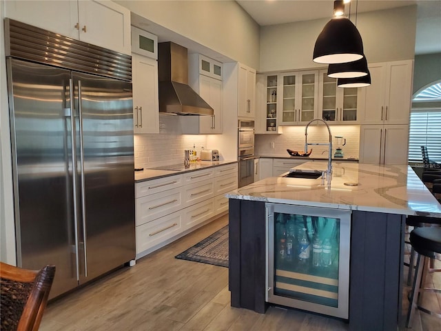 4216 Bur St, Port Charlotte, FL 33948 - kitchen featuring stainless steel appliances, wall chimney exhaust hood, beverage cooler, a sink, and light wood-type flooring