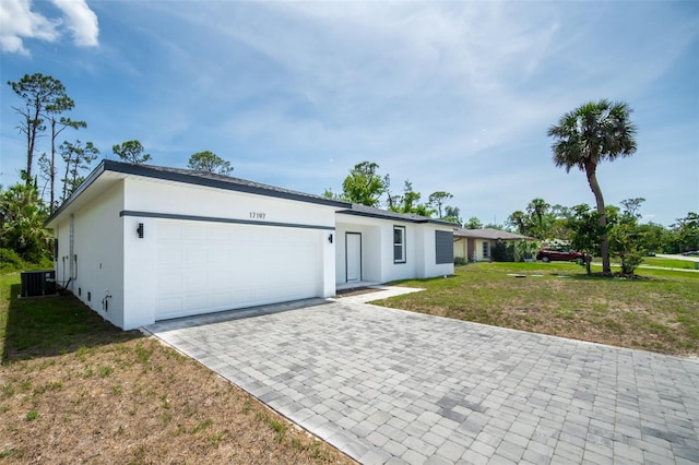 17197 Russell Ave, Port Charlotte, FL 33954 - view of front facade with stucco siding, decorative driveway, a garage, a front yard, and central air condition unit