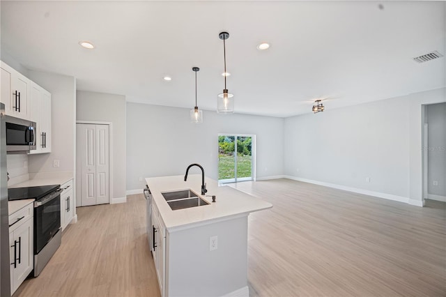 17197 Russell Ave, Port Charlotte, FL 33954 - kitchen with appliances with stainless steel finishes, a sink, light wood-style flooring, light countertops, and a center island with sink