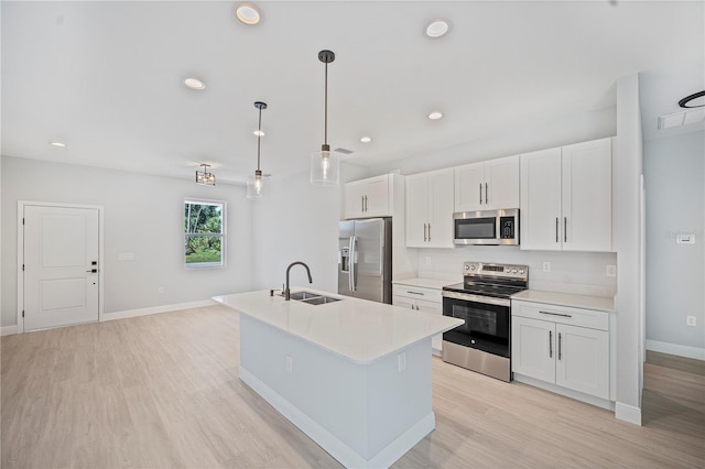 17197 Russell Ave, Port Charlotte, FL 33954 - kitchen featuring appliances with stainless steel finishes, a sink, light wood-style floors, baseboards, and an island with sink