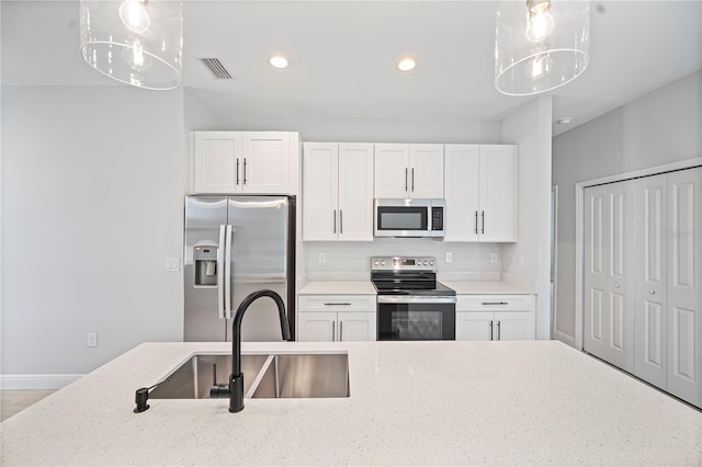 17197 Russell Ave, Port Charlotte, FL 33954 - kitchen with stainless steel appliances, a sink, white cabinetry, recessed lighting, and pendant lighting