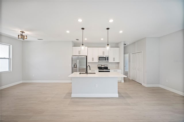 17197 Russell Ave, Port Charlotte, FL 33954 - kitchen featuring stainless steel appliances, a center island with sink, baseboards, light wood finished floors, and recessed lighting