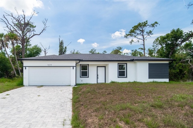 16218 Chamberlain Blvd, Port Charlotte, FL 33954 - view of front facade featuring stucco siding, an attached garage, and decorative driveway