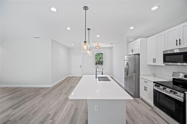 16218 Chamberlain Blvd, Port Charlotte, FL 33954 - kitchen featuring appliances with stainless steel finishes, a sink, light wood-type flooring, an island with sink, and white cabinetry