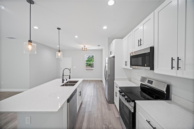 16218 Chamberlain Blvd, Port Charlotte, FL 33954 - kitchen featuring stainless steel appliances, a sink, light wood finished floors, a center island with sink, and white cabinets