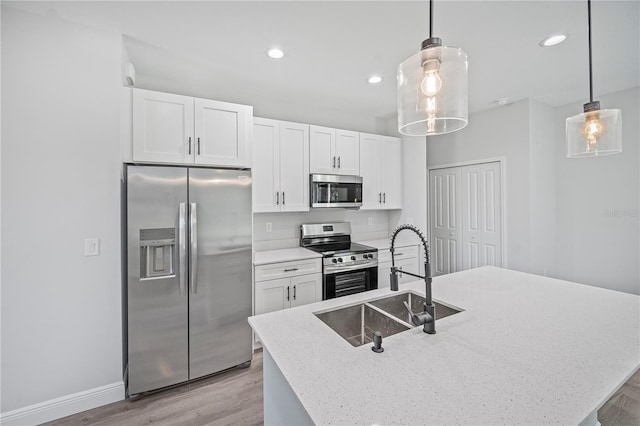 16218 Chamberlain Blvd, Port Charlotte, FL 33954 - kitchen with appliances with stainless steel finishes, a sink, light wood-style flooring, white cabinets, and recessed lighting