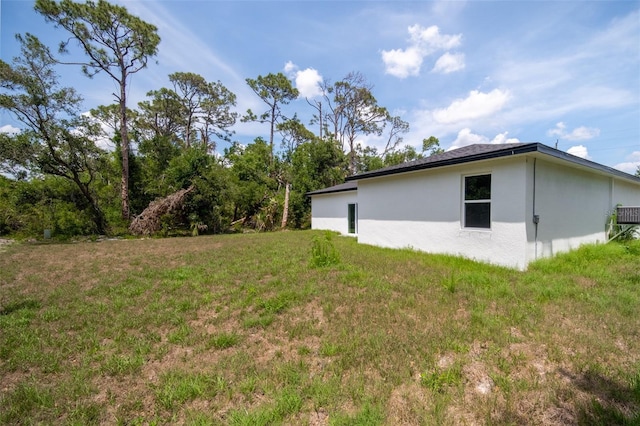 16218 Chamberlain Blvd, Port Charlotte, FL 33954 - view of property exterior with stucco siding and a yard