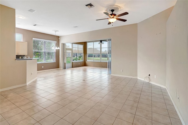 10263 Shadow Run Cir, Punta Gorda, FL 33955 - empty room with a ceiling fan, baseboards, light tile patterned floors, and a chandelier