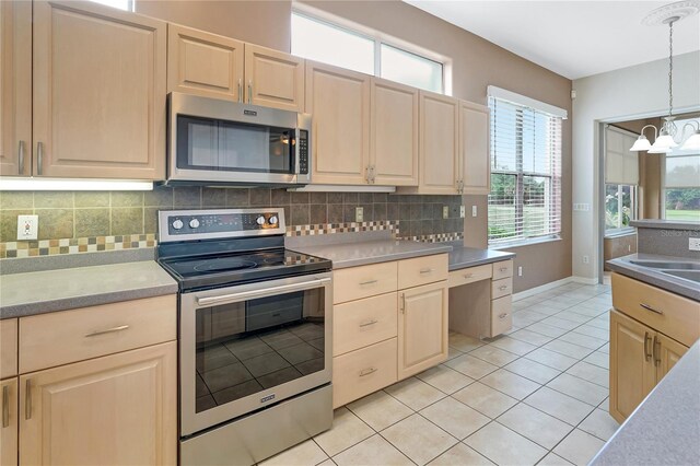 10263 Shadow Run Cir, Punta Gorda, FL 33955 - kitchen featuring stainless steel appliances, light brown cabinets, a chandelier, and decorative backsplash