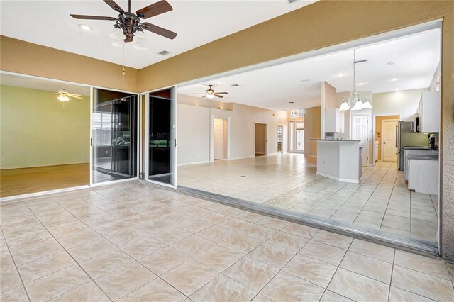 10263 Shadow Run Cir, Punta Gorda, FL 33955 - unfurnished room featuring light tile patterned floors, a ceiling fan, and a chandelier