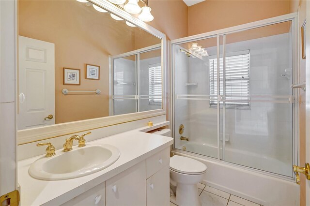 10263 Shadow Run Cir, Punta Gorda, FL 33955 - bathroom featuring vanity, toilet, tile patterned flooring, and combined bath / shower with glass door
