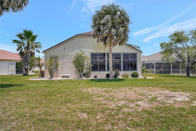 10263 Shadow Run Cir, Punta Gorda, FL 33955 - rear view of property with stucco siding and a lawn