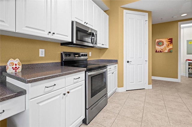 99 Vivante Blvd Unit 310, Punta Gorda, FL 33950 - kitchen with stainless steel appliances, white cabinetry, dark countertops, light tile patterned flooring, and baseboards