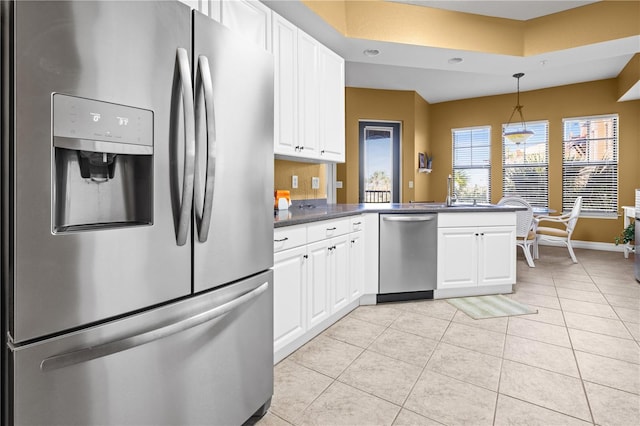 99 Vivante Blvd Unit 310, Punta Gorda, FL 33950 - kitchen with stainless steel appliances, light tile patterned floors, white cabinets, and dark countertops