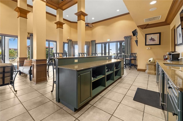 99 Vivante Blvd Unit 310, Punta Gorda, FL 33950 - kitchen featuring crown molding, healthy amount of natural light, a high ceiling, open shelves, and dark stone countertops