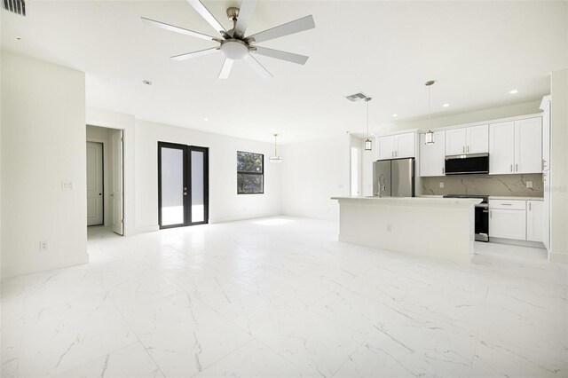 355 Milton St, Port Charlotte, FL 33954 - unfurnished living room with recessed lighting, light marble finish flooring, french doors, a ceiling fan, and a sink