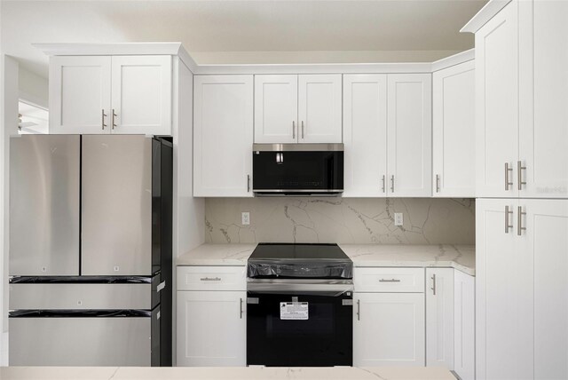 355 Milton St, Port Charlotte, FL 33954 - kitchen featuring appliances with stainless steel finishes, white cabinets, backsplash, and light stone countertops