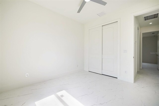 355 Milton St, Port Charlotte, FL 33954 - unfurnished bedroom with light marble finish floors, baseboards, a closet, and a ceiling fan