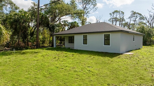 355 Milton St, Port Charlotte, FL 33954 - rear view of house featuring a lawn, stucco siding, and a shingled roof