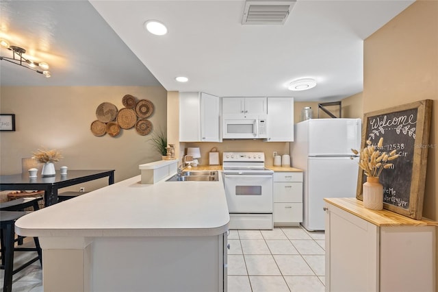 12538 SW Kingsway Cir Unit 1503, Lake Suzy, FL 34269 - kitchen with white appliances, a peninsula, light countertops, a sink, and recessed lighting