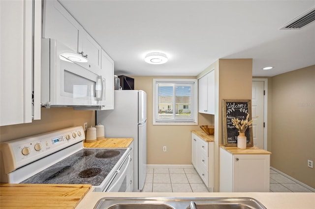 12538 SW Kingsway Cir Unit 1503, Lake Suzy, FL 34269 - kitchen featuring white appliances, light tile patterned floors, baseboards, white cabinetry, and butcher block counters