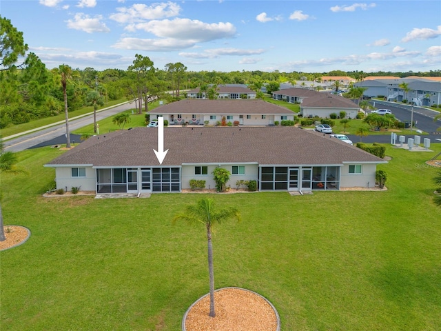 12538 SW Kingsway Cir Unit 1503, Lake Suzy, FL 34269 - rear view of house with a sunroom, roof with shingles, and a yard