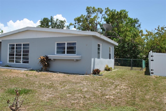 21275 Austin Ave, Port Charlotte, FL 33952 - view of side of home with stucco siding and a gate