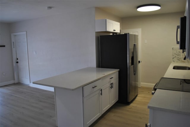 21275 Austin Ave, Port Charlotte, FL 33952 - kitchen featuring stainless steel fridge, light wood finished floors, light countertops, and baseboards