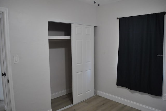 21275 Austin Ave, Port Charlotte, FL 33952 - unfurnished bedroom featuring wood finished floors, baseboards, and a closet