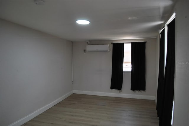 21275 Austin Ave, Port Charlotte, FL 33952 - empty room with an AC wall unit, baseboards, and wood finished floors