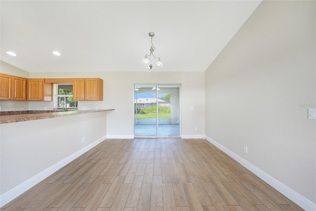 11615 SW Pine Ave, Arcadia, FL 34269 - kitchen with light wood-type flooring, baseboards, hanging light fixtures, recessed lighting, and vaulted ceiling