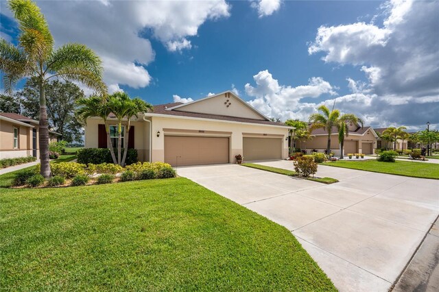 8866 Tuscany Isles Dr, Punta Gorda, FL 33950 - view of front of property with stucco siding, concrete driveway, a garage, and a front lawn