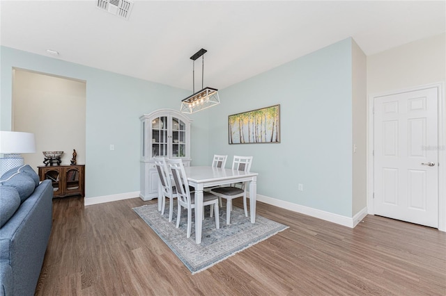 8866 Tuscany Isles Dr, Punta Gorda, FL 33950 - dining room featuring wood finished floors, baseboards, and a chandelier