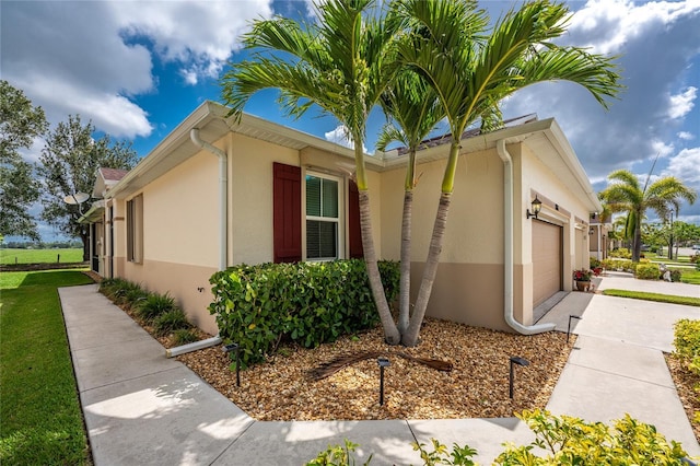 8866 Tuscany Isles Dr, Punta Gorda, FL 33950 - view of property exterior with an attached garage, stucco siding, and driveway