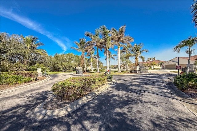 8866 Tuscany Isles Dr, Punta Gorda, FL 33950 - view of asphalt street featuring curbs, traffic signs, and a gated entry